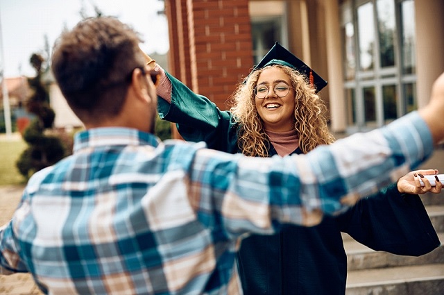 Glückliche Studentin feiert den Abschlusstag mit ihrem Vater an der Universität