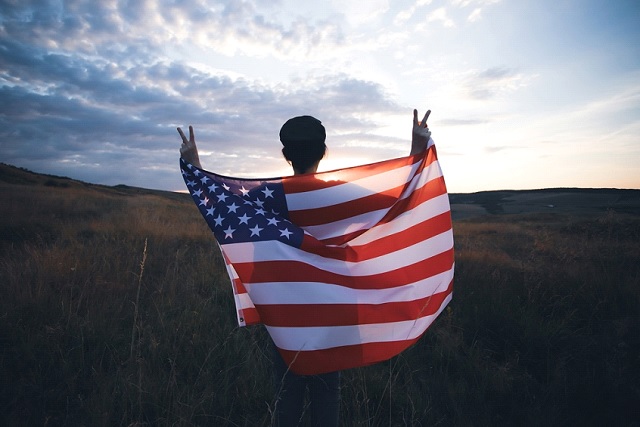Mit ESTA-Antrag und US-Flagge im Gepäck startet eine Frau ihre USA-Reise